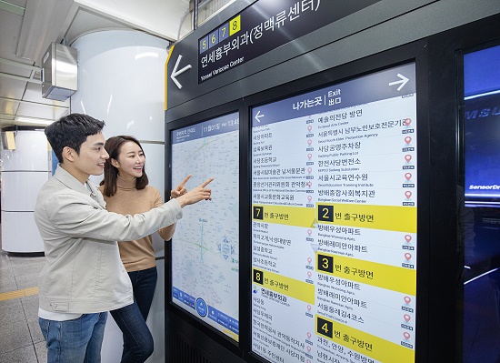 삼성전자 모델들이 서울 지하철 2·4호선 사당역에 설치된 삼성 스마트 사이니지 종합 안내도를 보고 있다. [삼성전자 제공]
